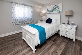 A bedroom with a bed and two night stands 
